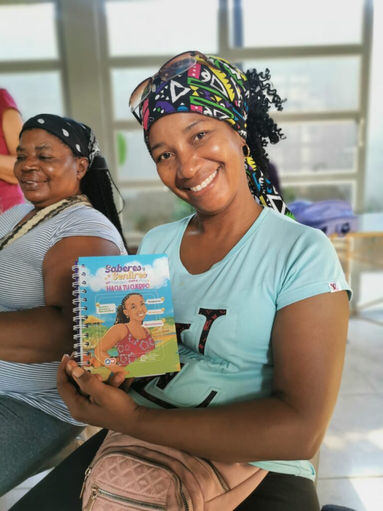 Foto de mujer sonriente sosteniendo un cuaderno